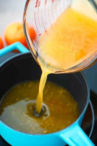 pouring orange juice in a saucepan