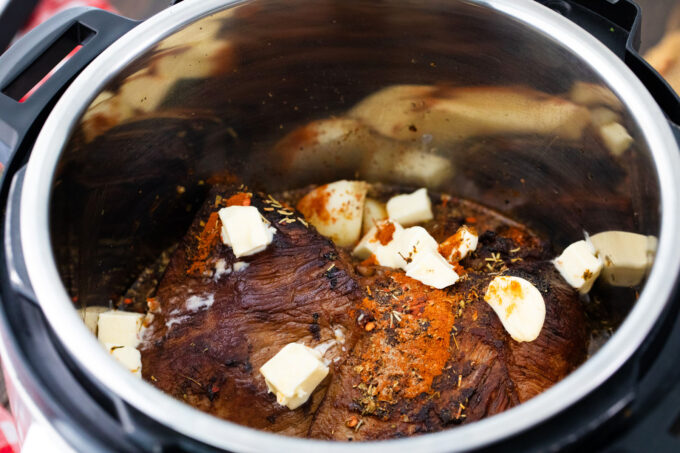 Adding to the Instant Pot all the ingredients for pot roast.