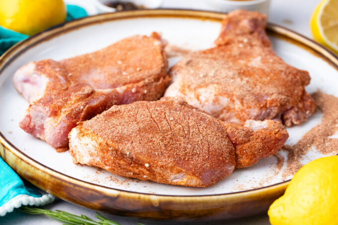Coating pork chops in homemade rub.