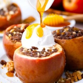 drizzling caramel sauce on slow cooker baked apples topped with ice cream