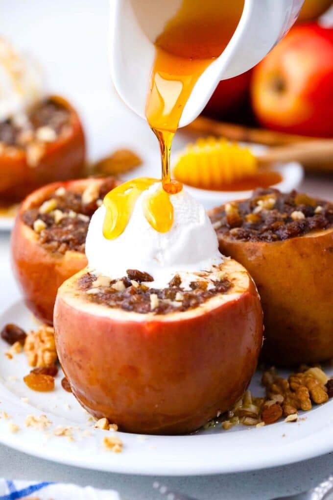 drizzling caramel sauce on slow cooker baked apples topped with ice cream