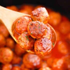 a wooden spoon filled with slow cooker buffalo chicken meatballs