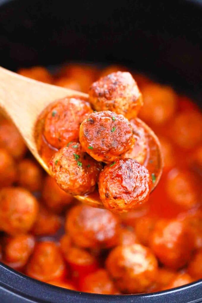 a wooden spoon filled with slow cooker buffalo chicken meatballs