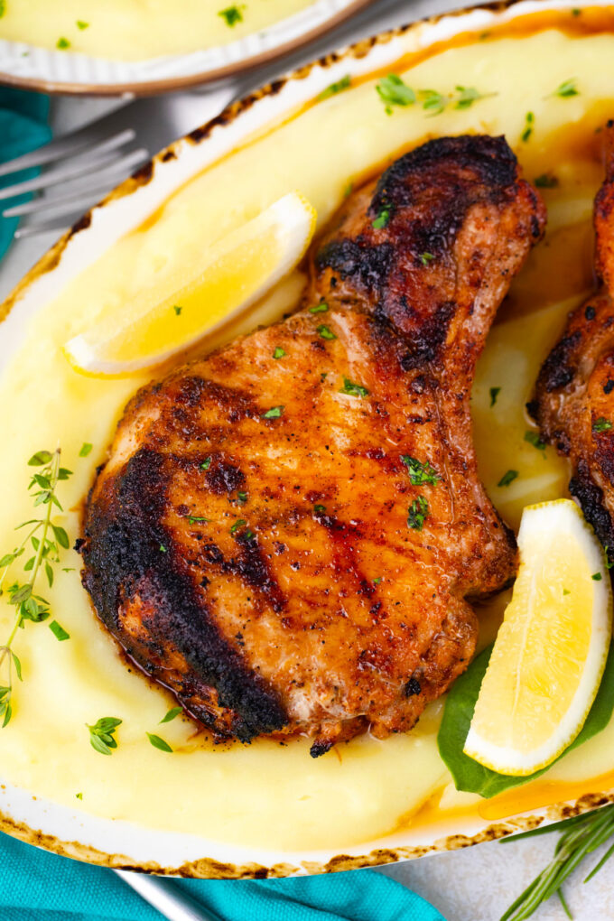 Perfectly grilled pork chops served with mashed potatoes and lemon.