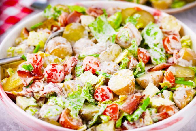 BLT potato salad with lettuce, tomatoes, and pickles.