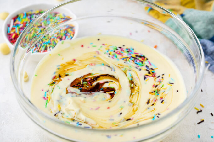 Stirring sprinkles into white chocolate fudge mixture.