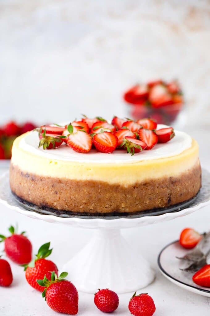 Cheesecake Factory original cheesecake copycat on a cake stand topped with strawberries