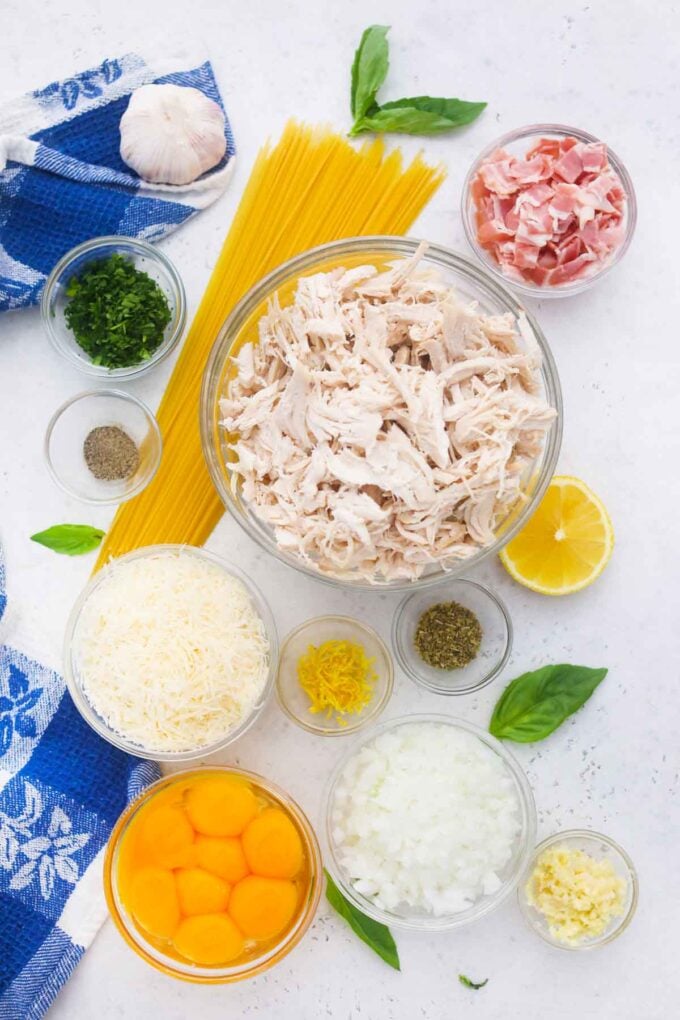 overhead shot of showing chicken carbonara ingredients in bowls on a table