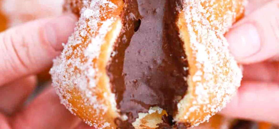 pulling chocolate custard filled donuts in half and revealing a chocolate center