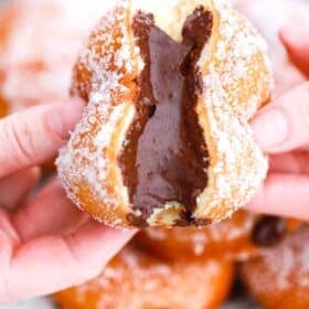 pulling chocolate custard filled donuts in half and revealing a chocolate center