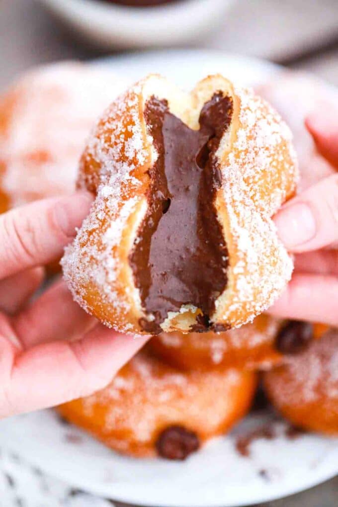 pulling chocolate custard filled donuts in half and revealing a chocolate center