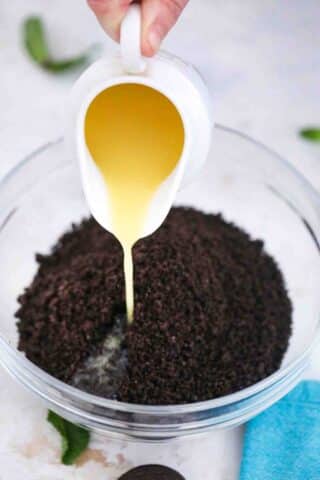 adding melted butter to Oreo crumbs