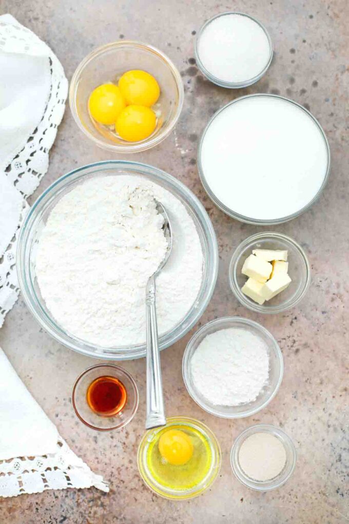 overhead shot of eggs flour sugar yeast butter in bowls on a table