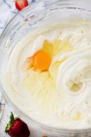adding eggs to cheesecake batter
