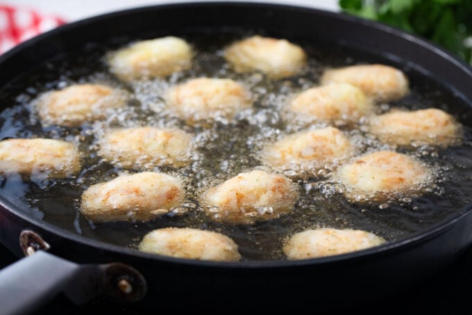Frying tater tots in oil.