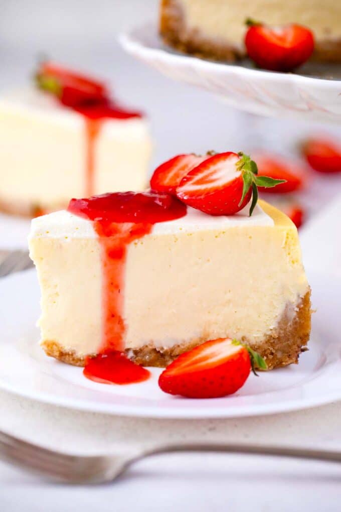 sliced Cheesecake Factory original cheesecake copycat topped with strawberries and strawberry sauce