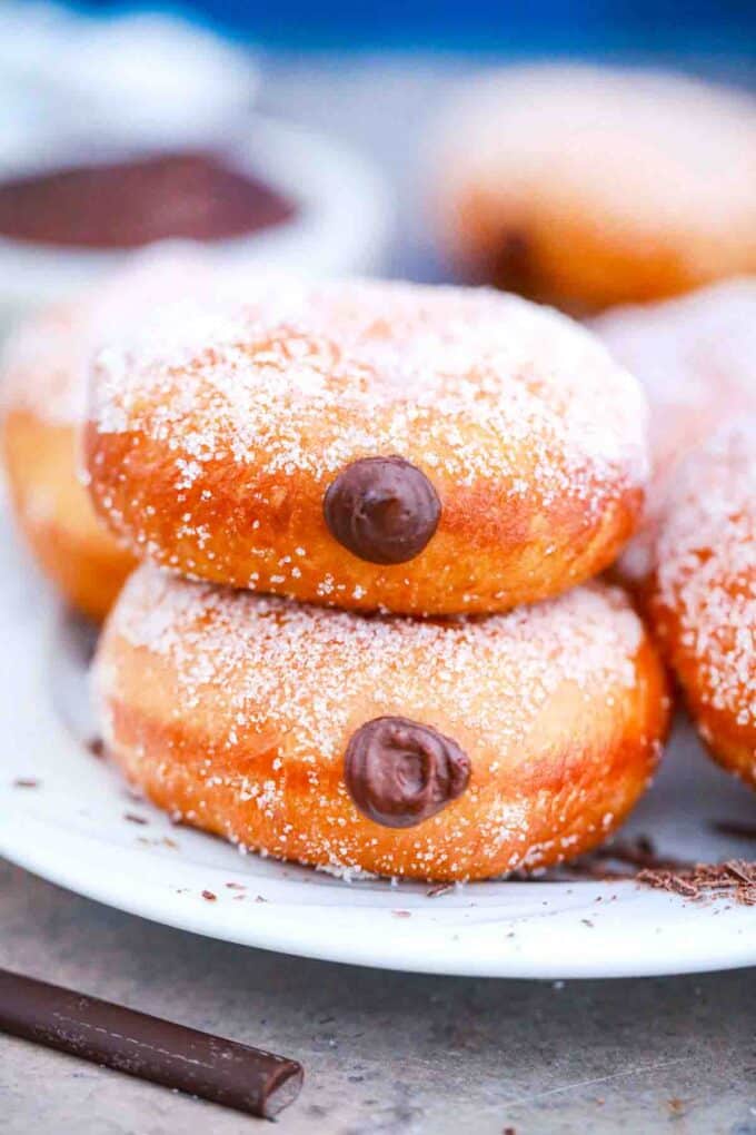 homemade chocolate custard donuts stacked on a plate