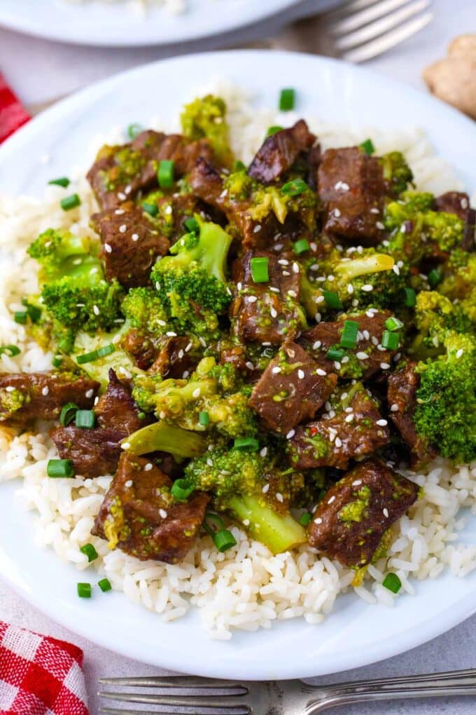 A plate of rice topped with beef and broccoli.
