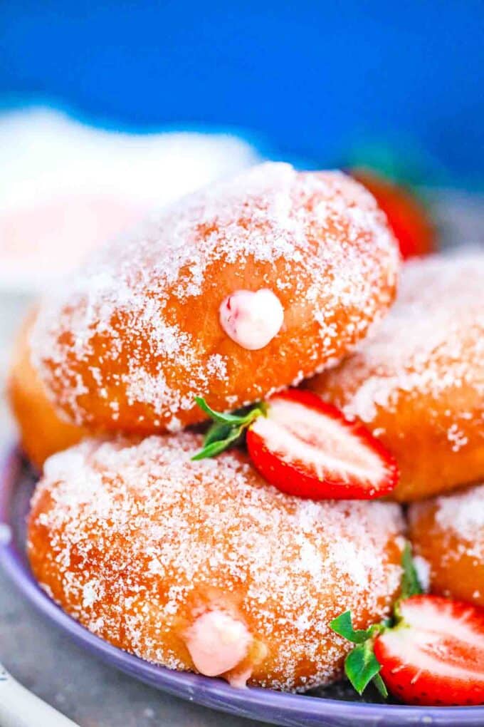 close macro shot of strawberry custard filled donuts covered in sugar