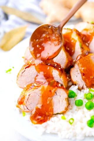 Drizzling honey garlic sauce over sliced homemade instant pot pork tenderloin.