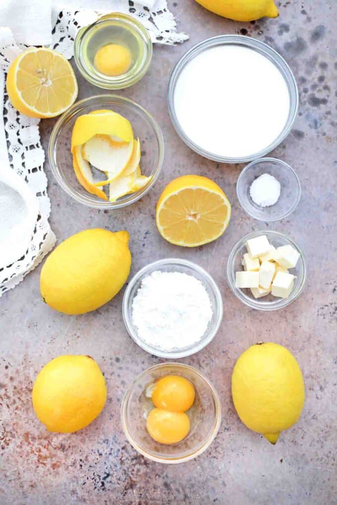 overhead shot of milk sugar eggs lemon butter in bowls on a table