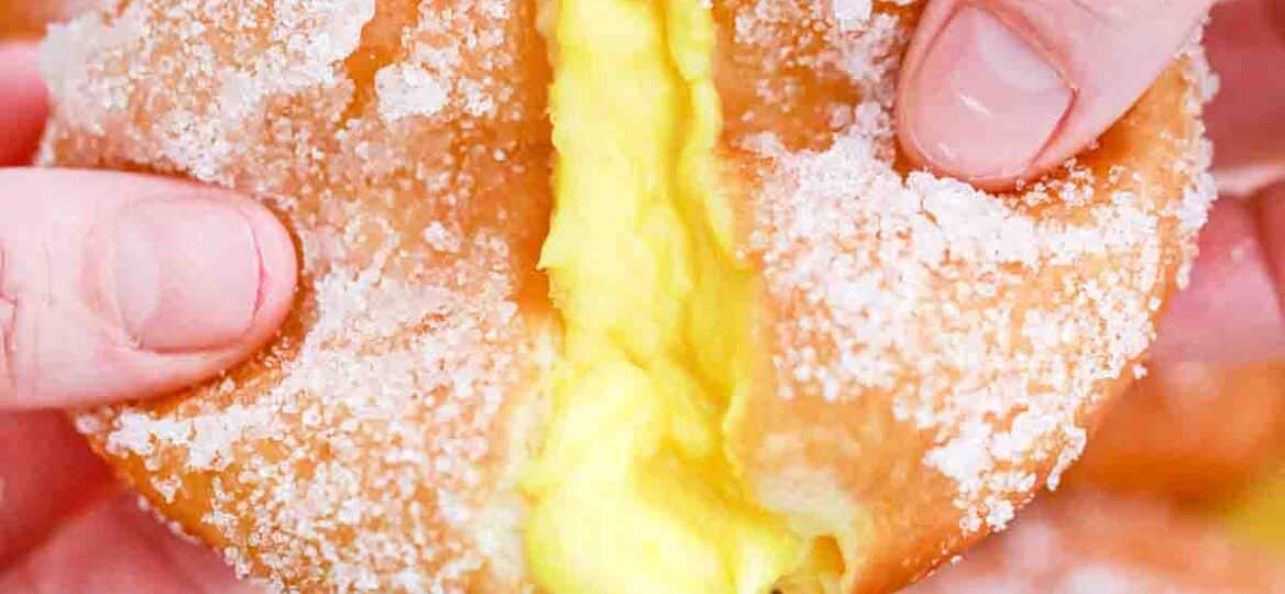 pulling apart a lemon curd filled donut and revealing a custard center