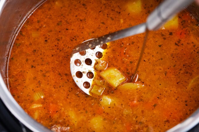 Mashing potatoes in Instant Pot cheeseburger soup.