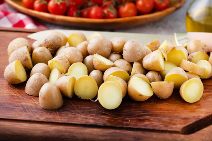 Sliced boiled potatoes on a cutting board.