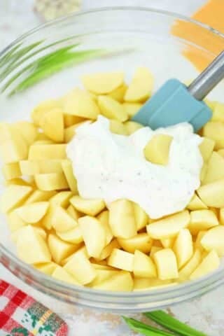 mixing potatoes and ranch dressing in a bowl