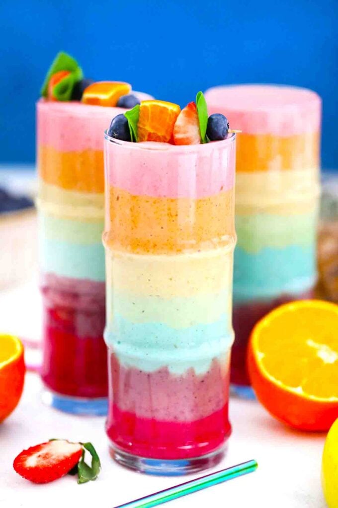 rainbow smoothie layered in different colors in glasses