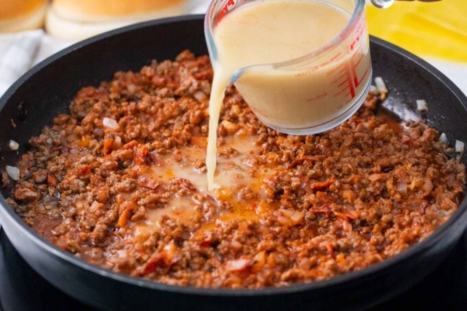 Adding cornstarch sully to beef mixture in a skillet.