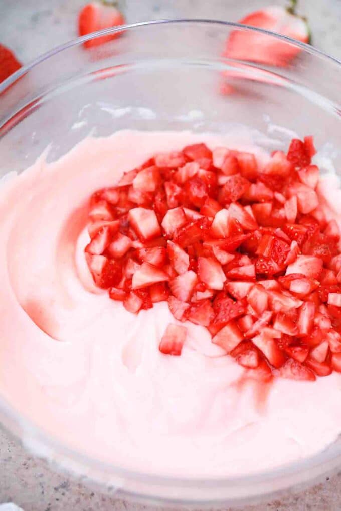 adding fresh strawberries to strawberry custard