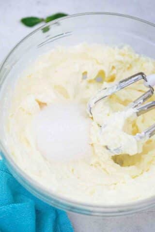 beating sugar and cream cheese in a bowl