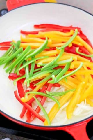 cooking red yellow and green sliced bell peppers