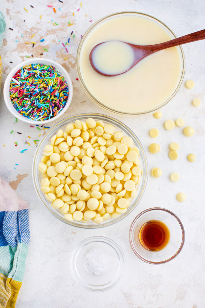 Overhead shot of white chocolate fudge ingredients arranged on a white surface.