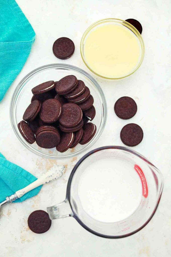 overhead shot of Oreos sipping cream and condensed milk in bowls on a table