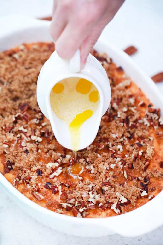 Drizzling melted butter on top of sweet potato souffle.