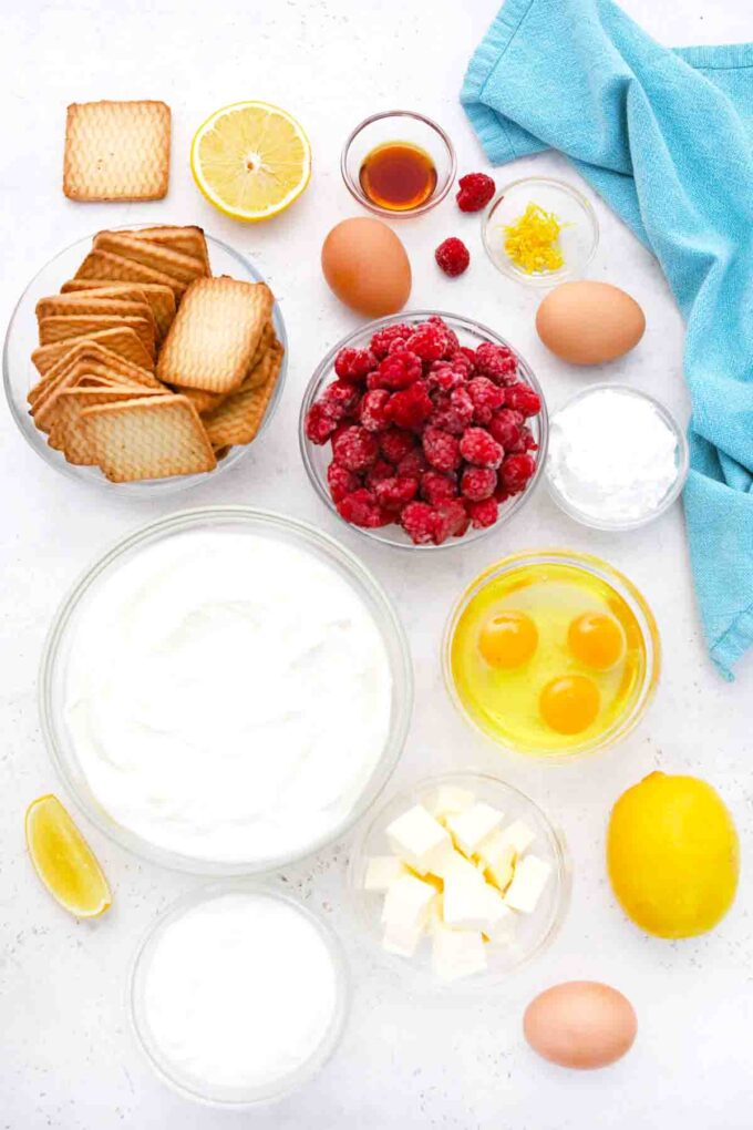 overhead shot of eggs cream cheese sour cream lemon butter raspberries in bowls on a table