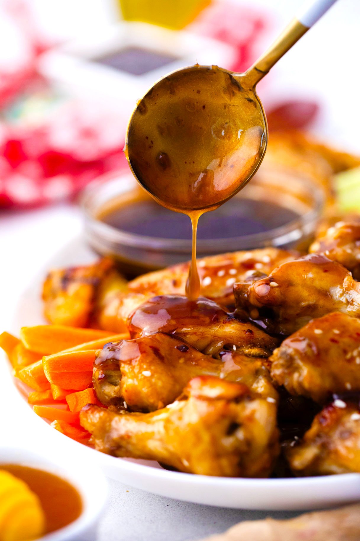 Drizzling honey garlic ginger sauce over instant pot chicken wings.