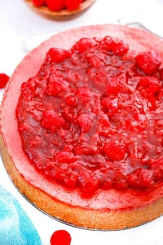 raspberry cheesecake topped with raspberry sauce and fresh raspberries
