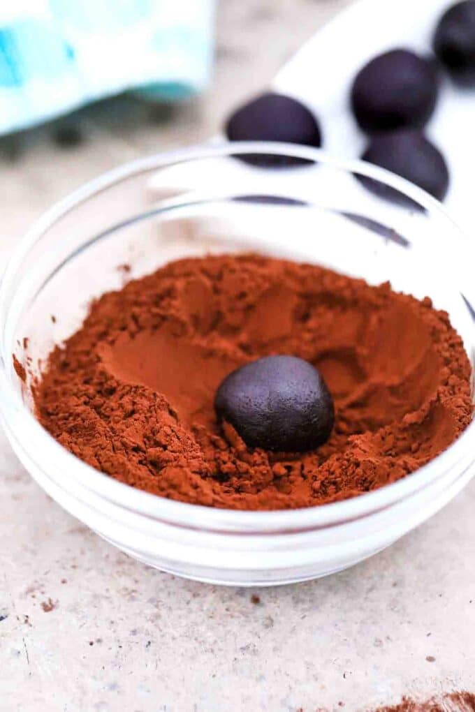rolling a chocolate truffle in cocoa powder