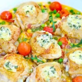 creamy corn chicken thighs in a creamy sauce with cherry tomatoes and peas