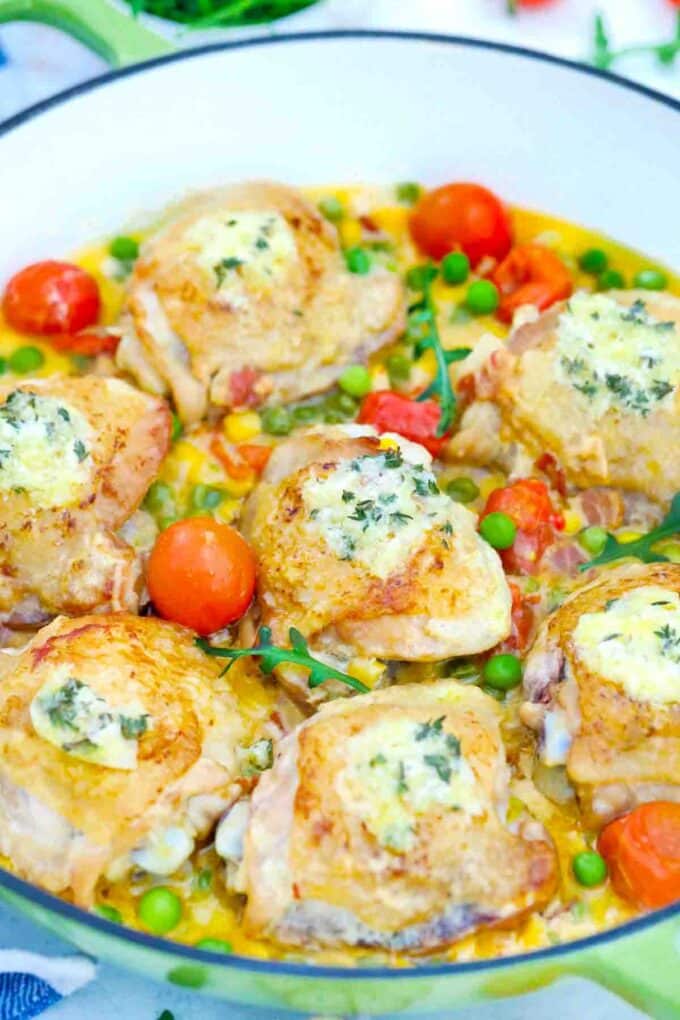 creamy corn chicken thighs in a creamy sauce with cherry tomatoes and peas