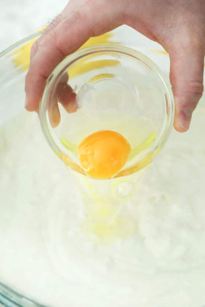 adding an egg to ricotta cheese in a bowl