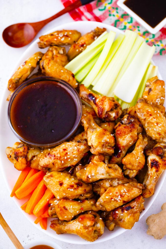 A platter of instant pot chicken wings with celery, carrots, and dipping sauce.