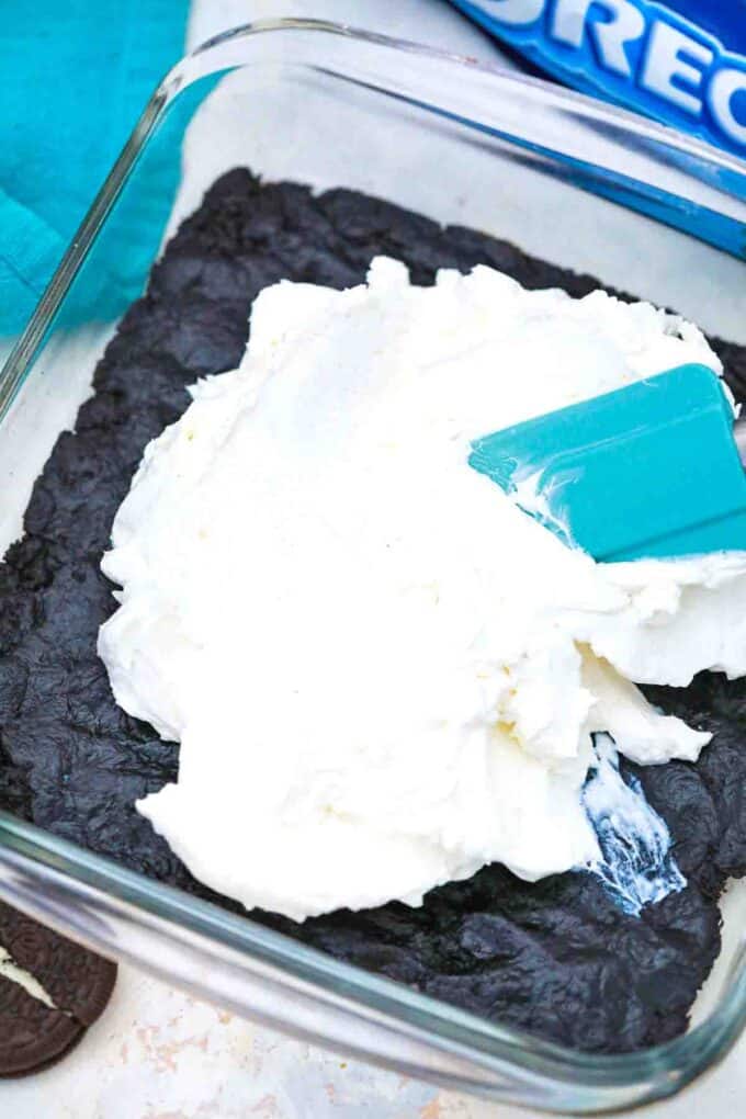 adding whipped cream on top of oreo crust