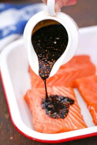 adding maple syrup and soy sauce mixture on top of salmon fillets
