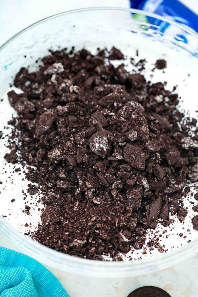 adding crushed oreo crumbs to whipped cream mixture