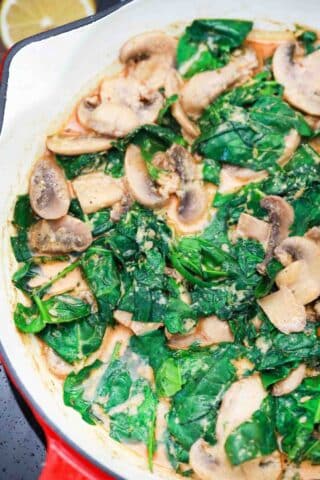cooking spinach and mushrooms in a pan