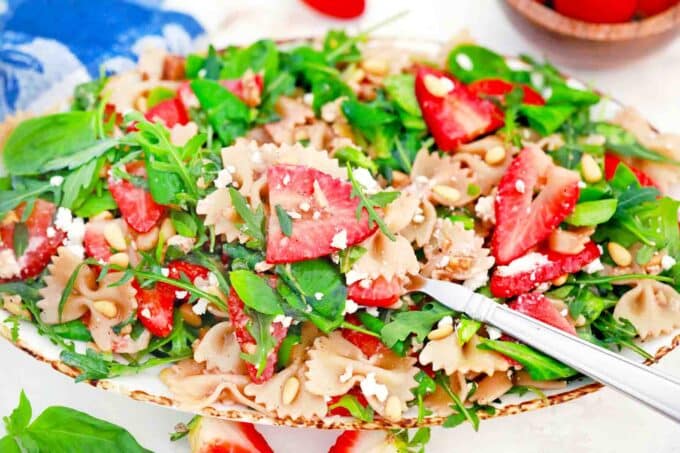 strawberry balsamic pasta salad with bow tie pasta and arugula
